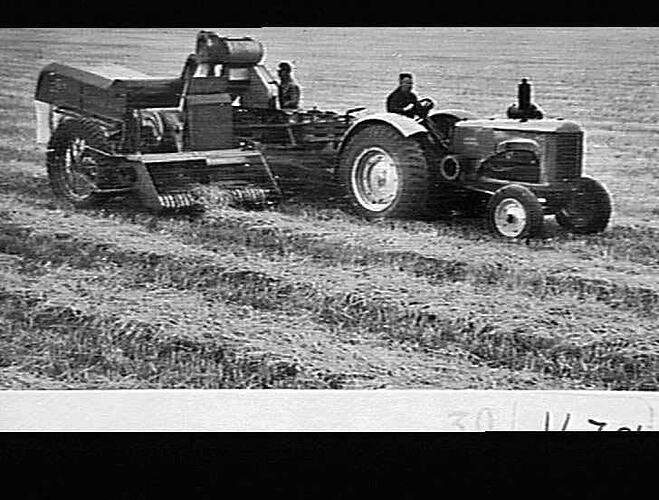 Tractor pulling bailer machinery.