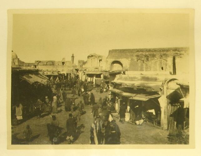 Street scene in Baghdad with buildings and people.