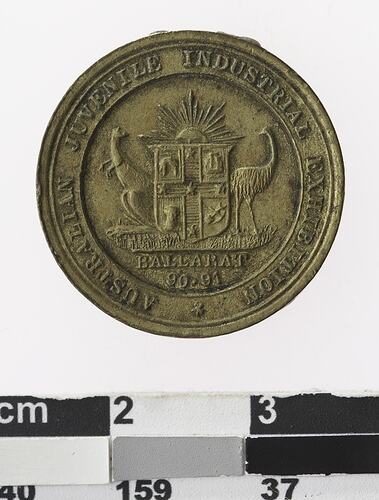 Round bronze coloured medal with coat of arms, text surrounding