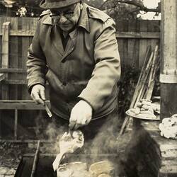Man in Coat & Hat Cooking Chops on Barbecue, Caulfield, 1968