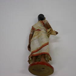 Indian Figure on red stand - back view