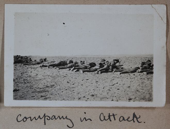 Row of servicemen laying on ground.