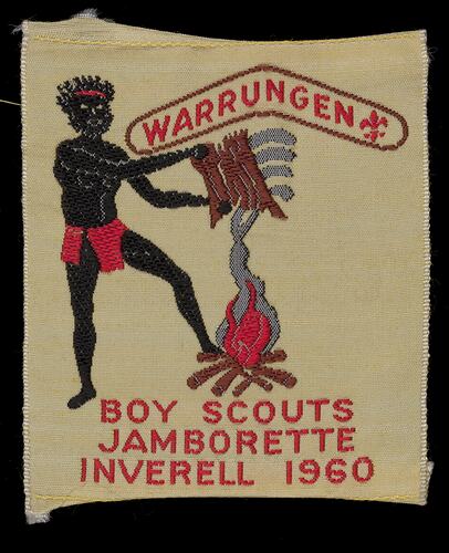 Aboriginal man fanning smoke from a campfire. Embroidered on fabric with text above and below.