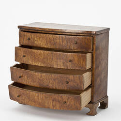 Bow fronted chest with open drawers.