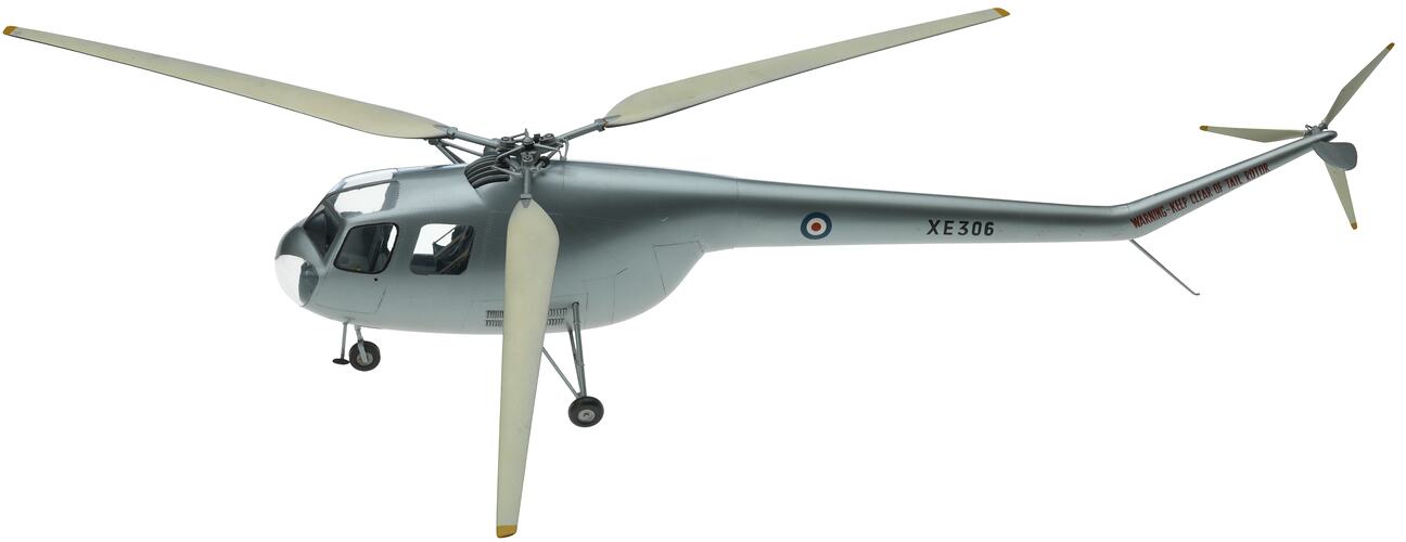 Metal model helicopter painted silver with three propellers and three wheels.