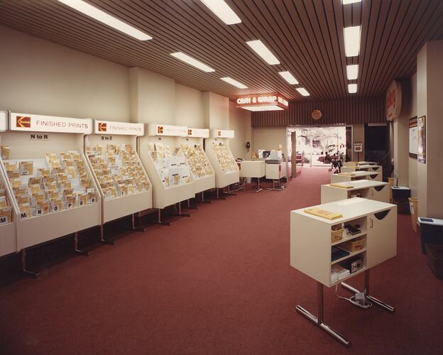 Long, carpeted room with free-standing shelving.