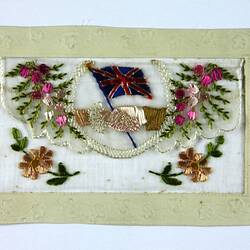 Front of postcard with embroidered flowers and flags.