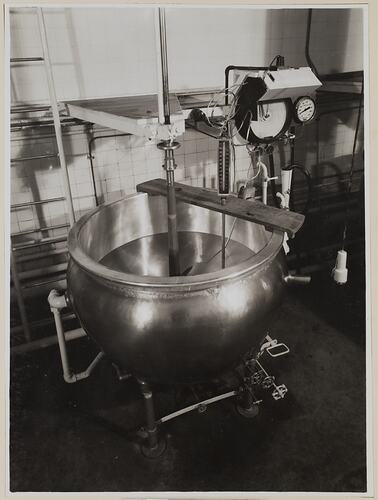 Large vat, connected to pipes and dials.