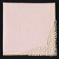 Pink handkerchief with lace corner.