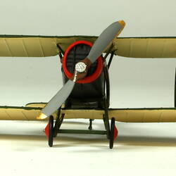 Dark green aeroplane model with white underside of wings featuring a red, white, blue circle. Front view with