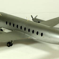 Silver model aeroplane with two propellers on each wing. Back view.