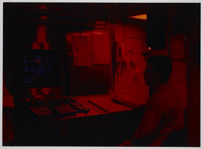 Man seated at a control panel.