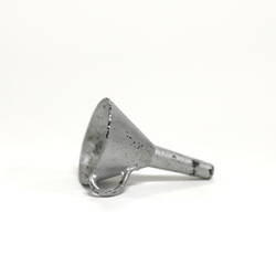Side view of tiny metal funnel.