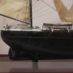 Detail of sailing ship model in glass case, facing right.