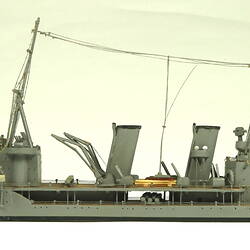 Naval ship with two masts, facing left.