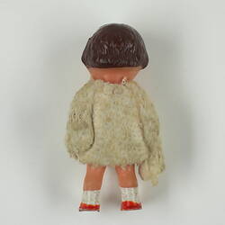 Back of little boy doll in white jumper.