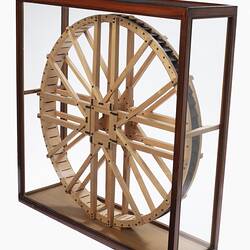 Wooden model of a water wheel. In case. Three quarter view.