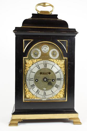 Front view of a clock in a balck and gold case.