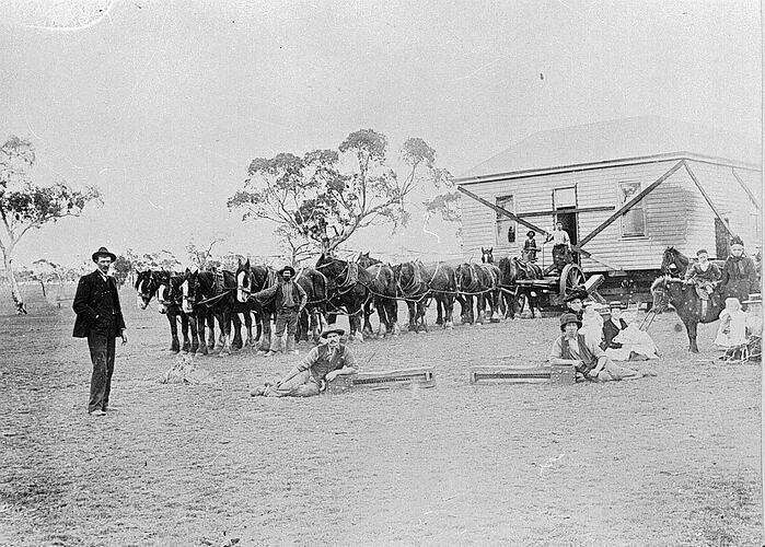 [William Trege (left) supervises the removal of a house by a team of horses, St Arnaud, about 1905.]
