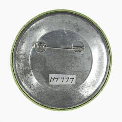 Silver back of round badge. Horizontal pin.