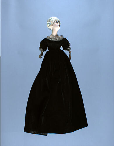 Front view of doll-shaped telephone cover with black dress.