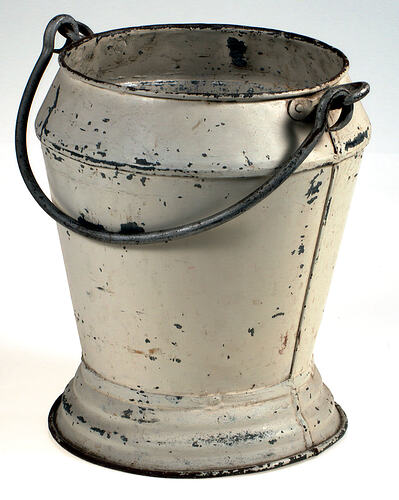 Side view of metal bucket painted white.