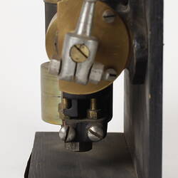 Sectioned Smith's carburettor on black stand. Left profile.