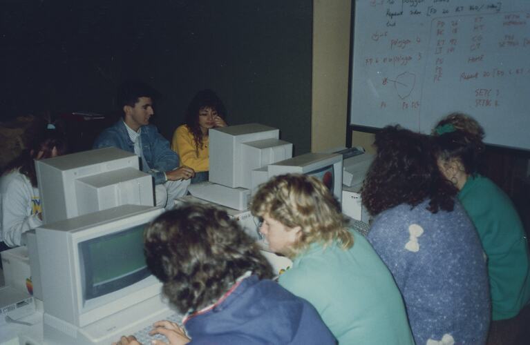 Students sitting on the floor working on computers.