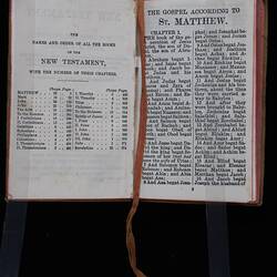 Open book with printed text in black on both pages. Pink cloth tape page marker.