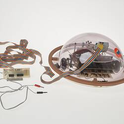 Profile of clear dome containing computer components. Cable attached.