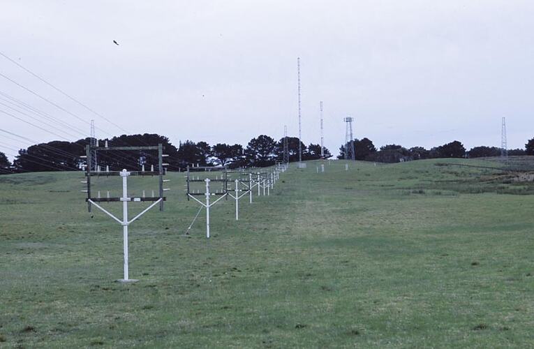 MM 028499 Transmit feeder lines. Antenna for medium frequency morse transmitter in background. Melbourne Coastal Radio Station, Cape Schanck