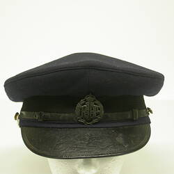 Navy cap with leather visor and metal badge on hat band.