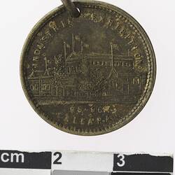 Round medal with building, text above and below.