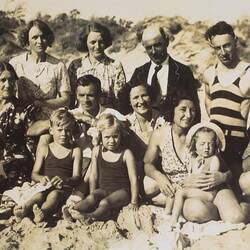 Group of people posing at a beach.
