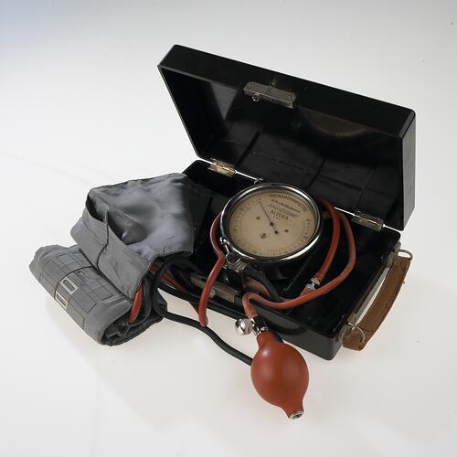 Medical equipment with cuff, dial and pump for measuring blood pressure.