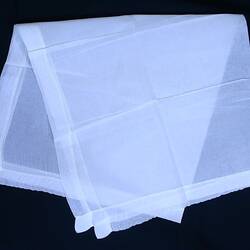White cotton gauze veil, folded in half.