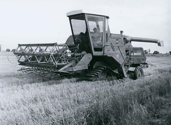 Front left of grain harvester fitted with crawler tracks.