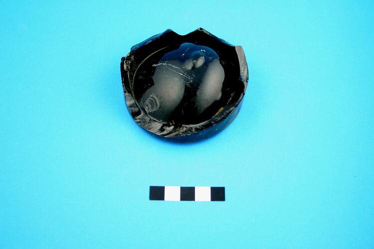 Broken base of a beer or wine bottle.