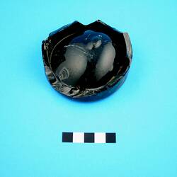 Broken base of a beer or wine bottle.