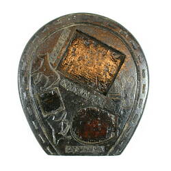 Carved object, horse shoe shaped.