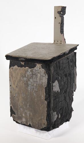 Fire damaged off-white painted wooden box with flap lid, charred black on one side.