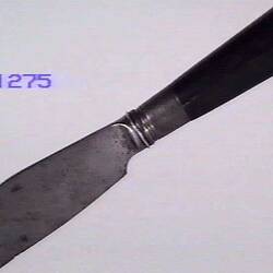 Side view of knife with curved blade.