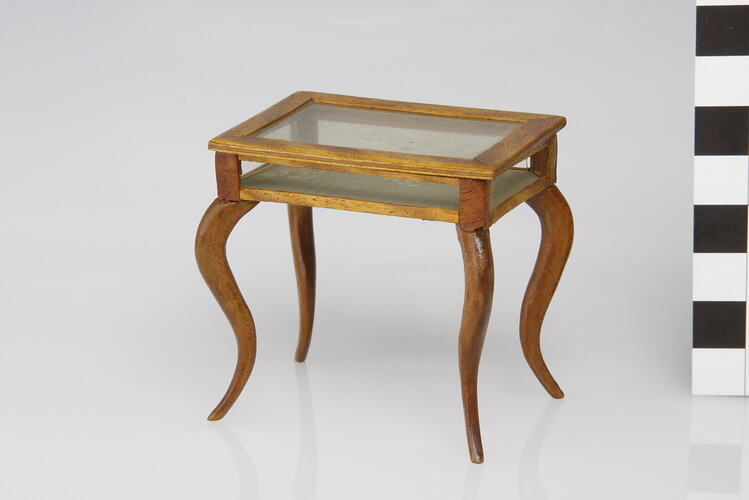 Rectangular display table with hinged glass top.