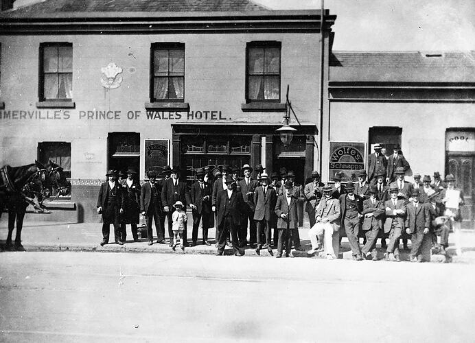 Group of people in front of Sommerville 's Prince of Wales Hotel. There are two horses on the left.