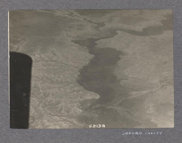Aerial view of land, long shadow in left edge of photo.
