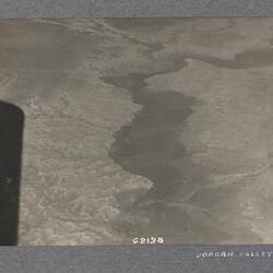 Aerial view of land, long shadow in left edge of photo.