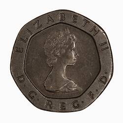 Seven-sided coin with profile of woman wearing tiara, text around.