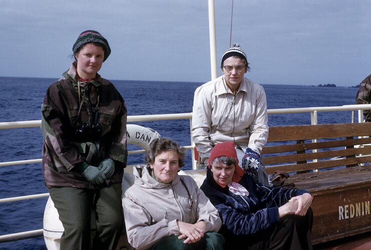 Four women on ship deck.