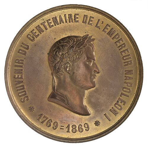 Round bronze medal with male facing right.Text around edge.