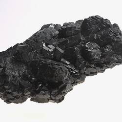 Blocky black crystals forming a rock sample.